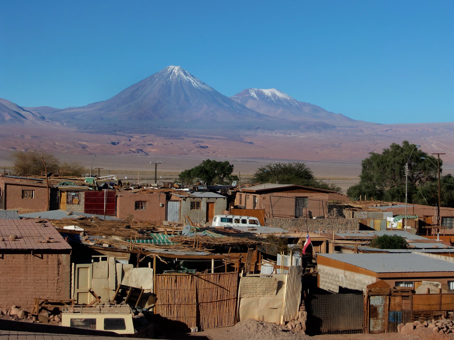 The suburbs of San Pedro de Atacama with the Volcanoes Licancabur and Juriques